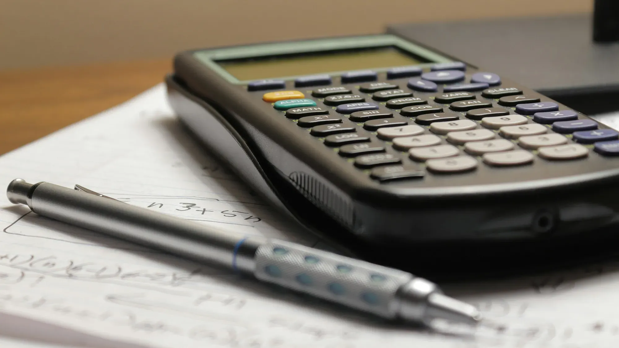 Calculadora y bolígrafo sobre una hoja de papel con cifras